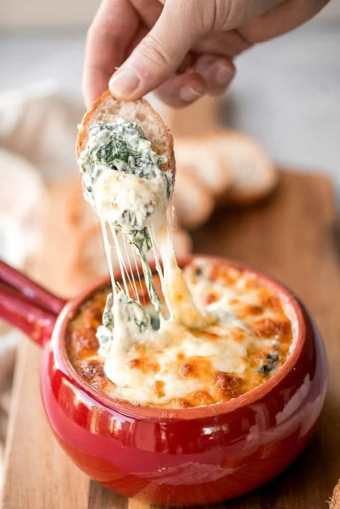 Delicious baked spinach dip served in a rustic dish with tortilla chips.