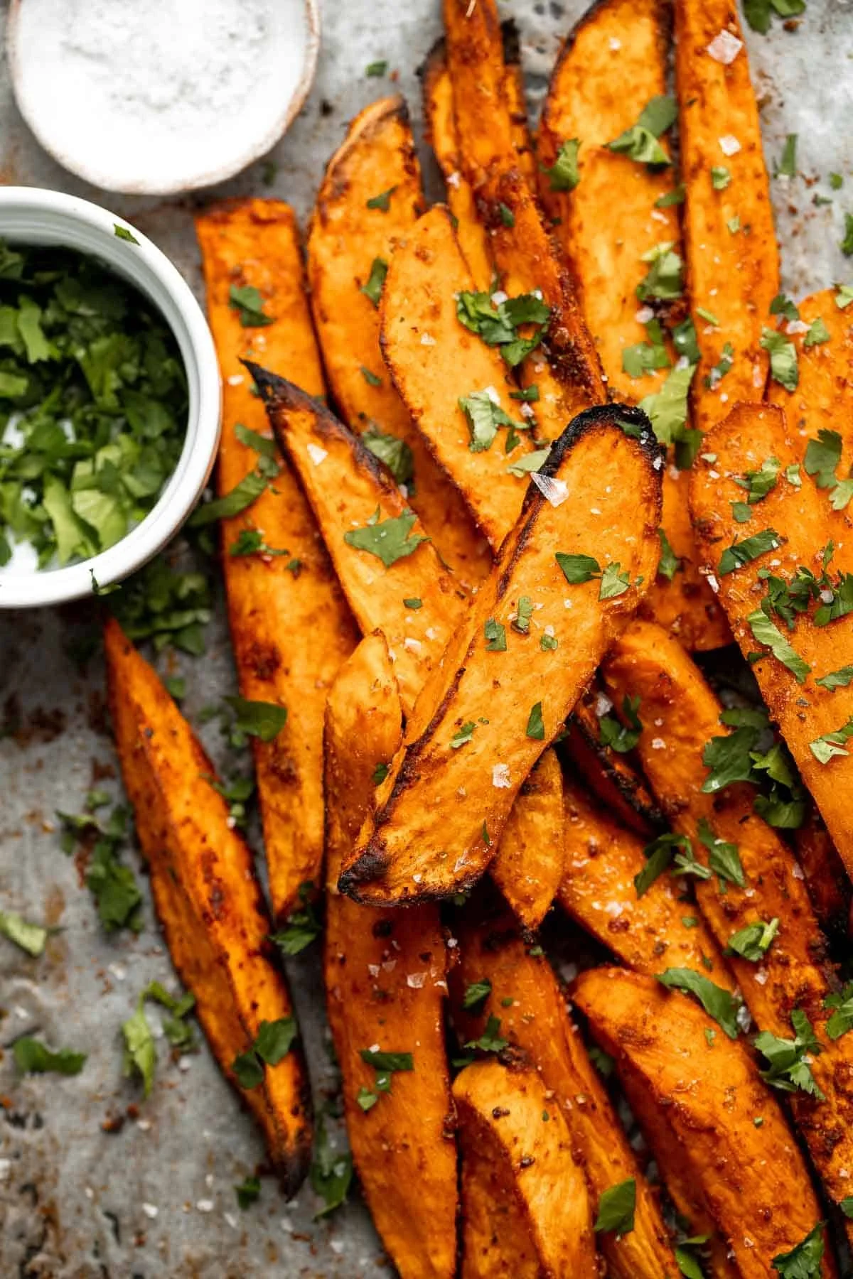 Baked sweet potato wedges served with dipping sauce on a plate