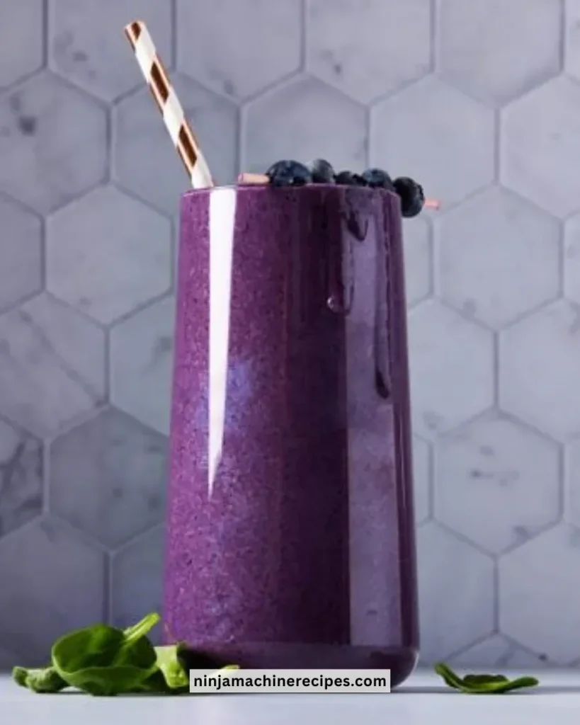 Delicious blueberry smoothie in a glass with fresh berries on the side