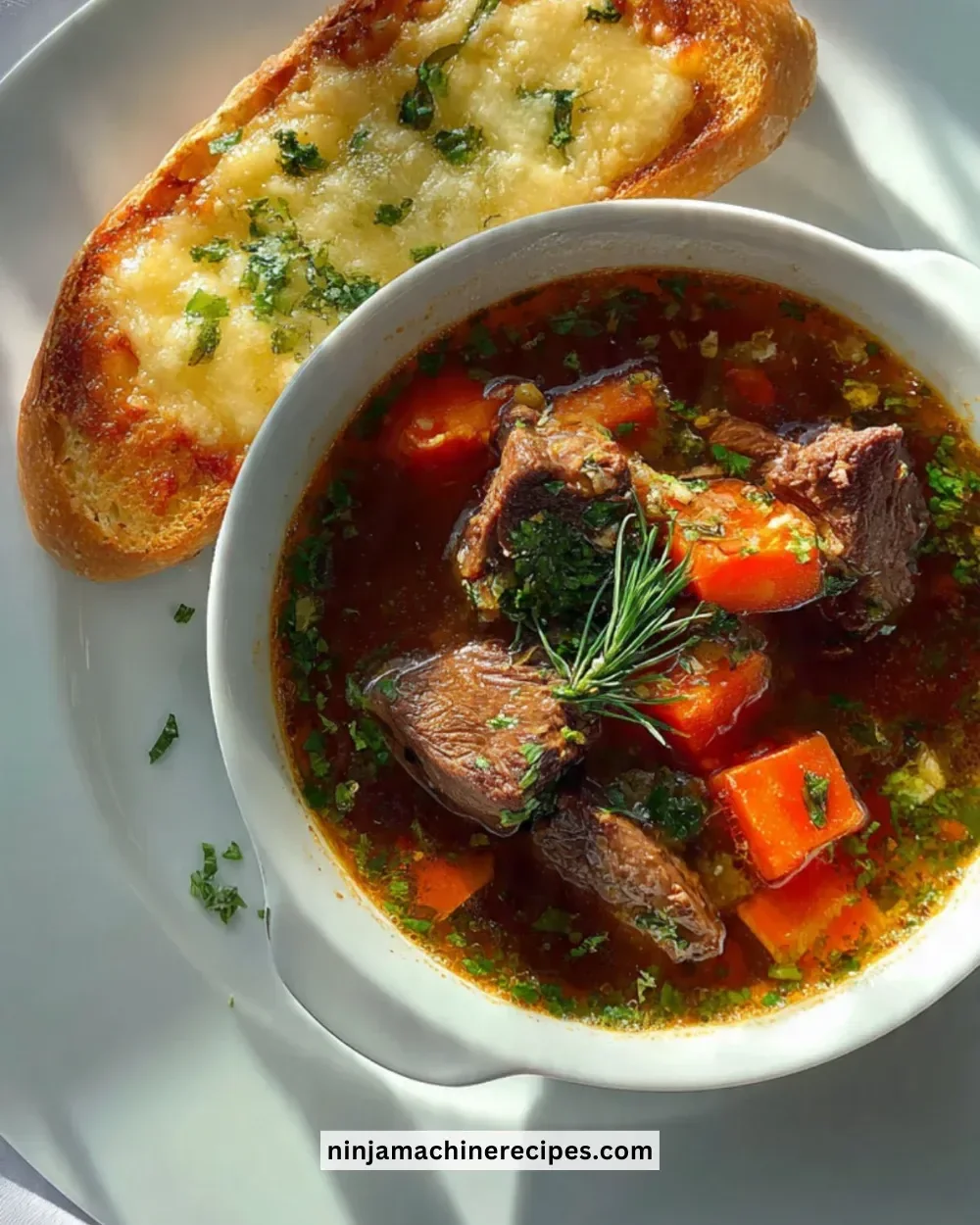 Bowl of braised beef soup with a side of cheesy bread on a rustic table
