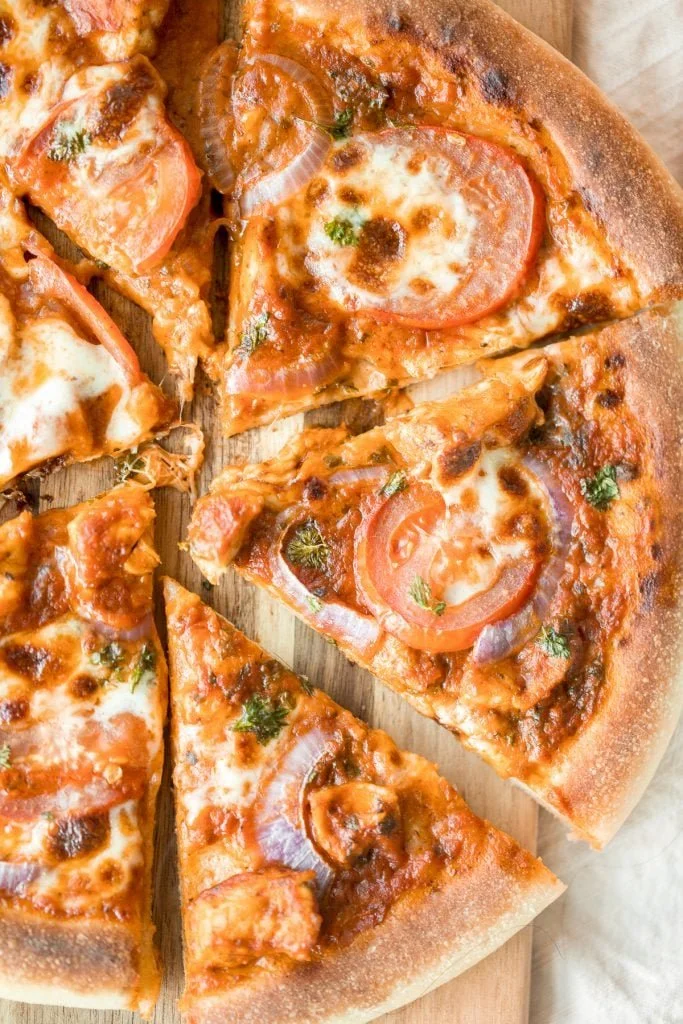 Delicious Butter Chicken Pizza topped with rich sauce and fresh herbs