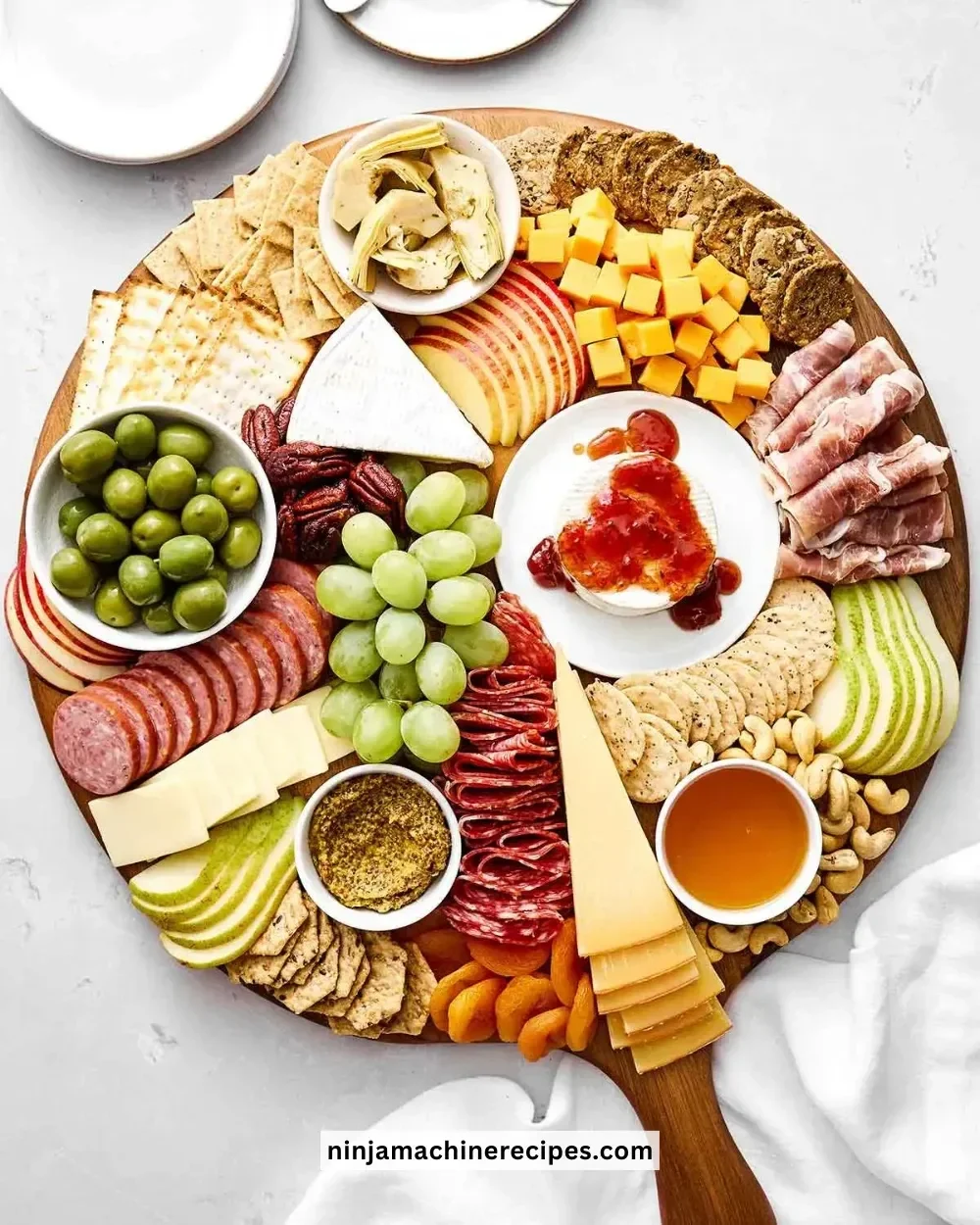 A beautifully arranged charcuterie board with meats, cheeses, and fruits.