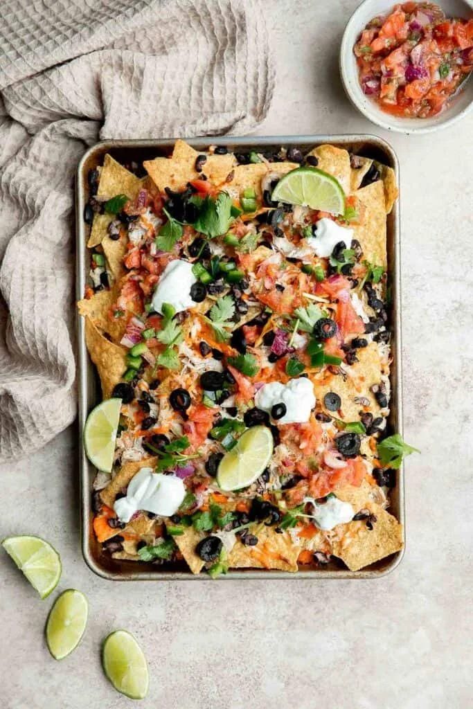 Delicious Chicken Nachos topped with cheese, jalapeños, and fresh toppings.
