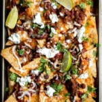 A mouth-watering plate of chili nachos topped with melted cheese and jalapeños.
