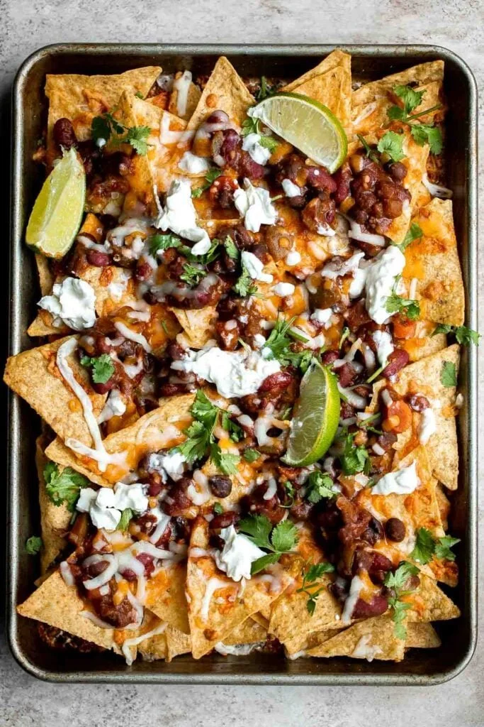 A mouth-watering plate of chili nachos topped with melted cheese and jalapeños.
