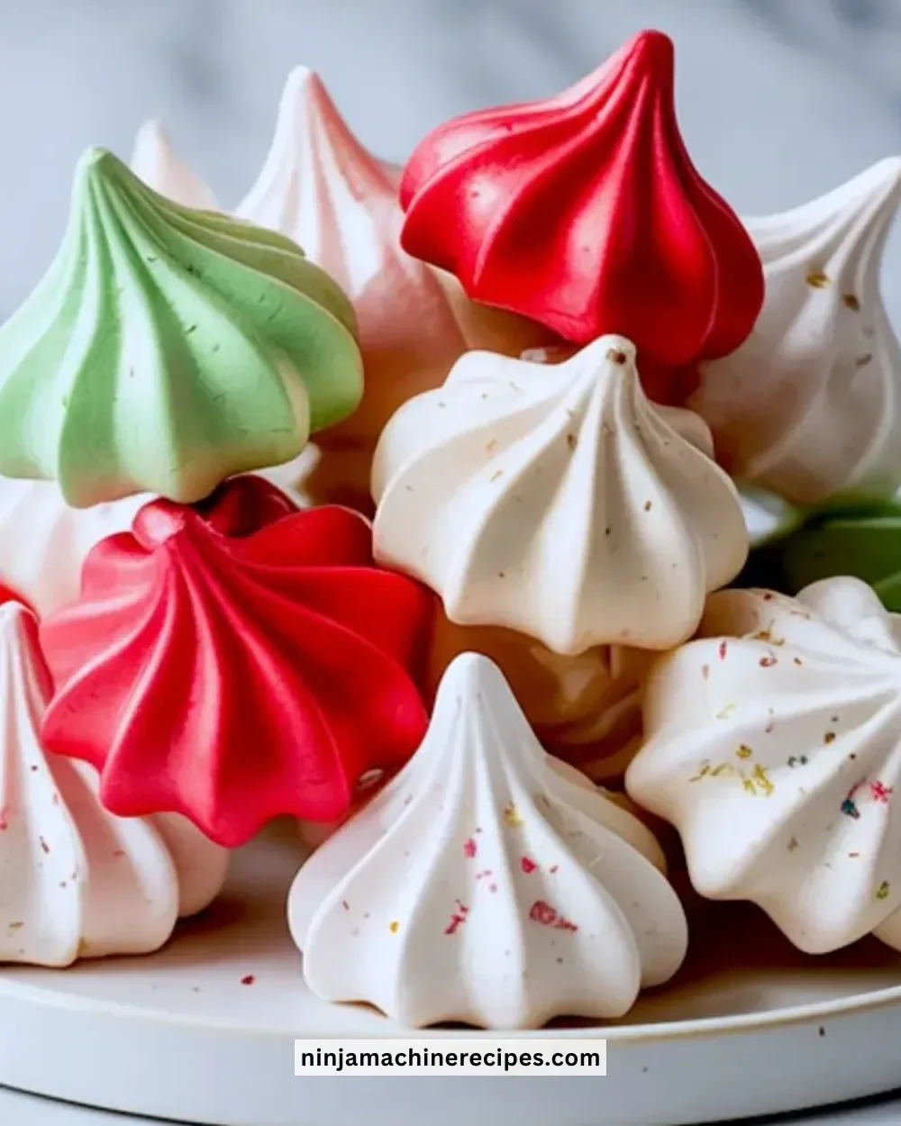 A plate of beautifully decorated Christmas meringue cookies for the holiday season.