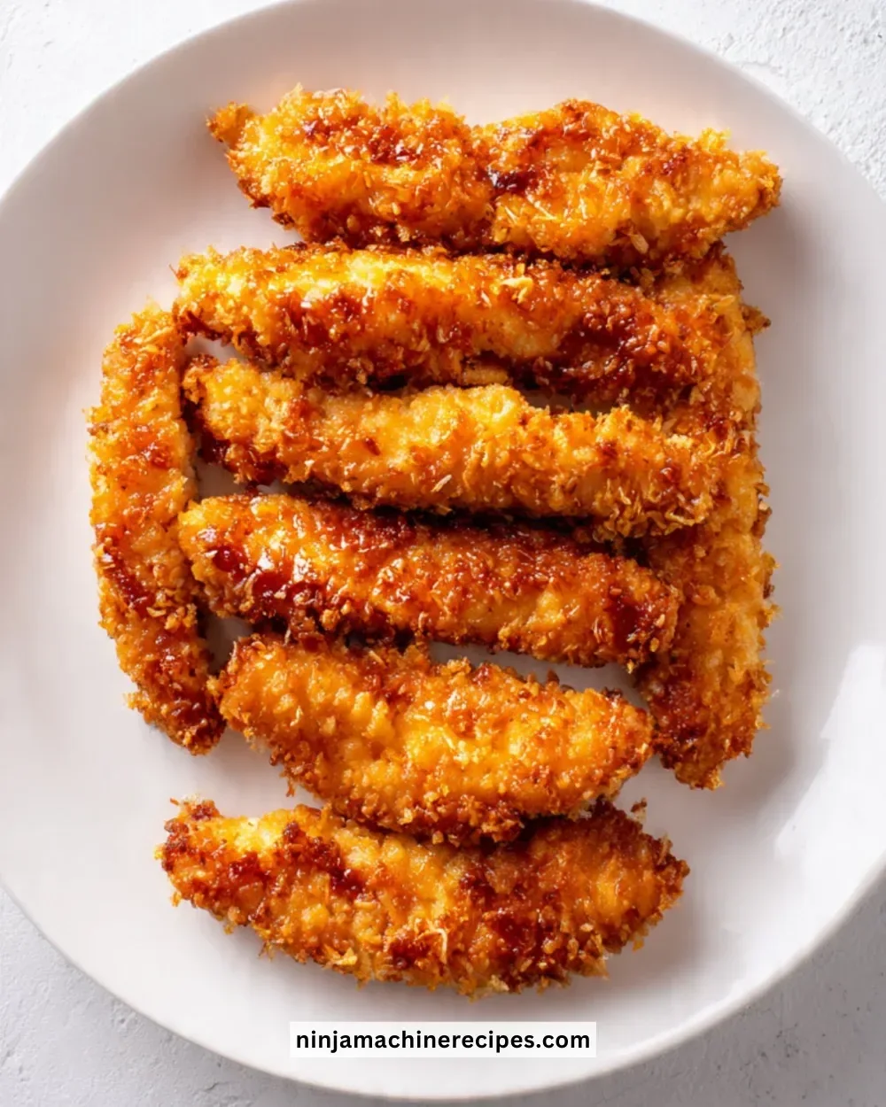 Crispy Honey Butter Garlic Chicken Strip served on a plate with sauce and garnish