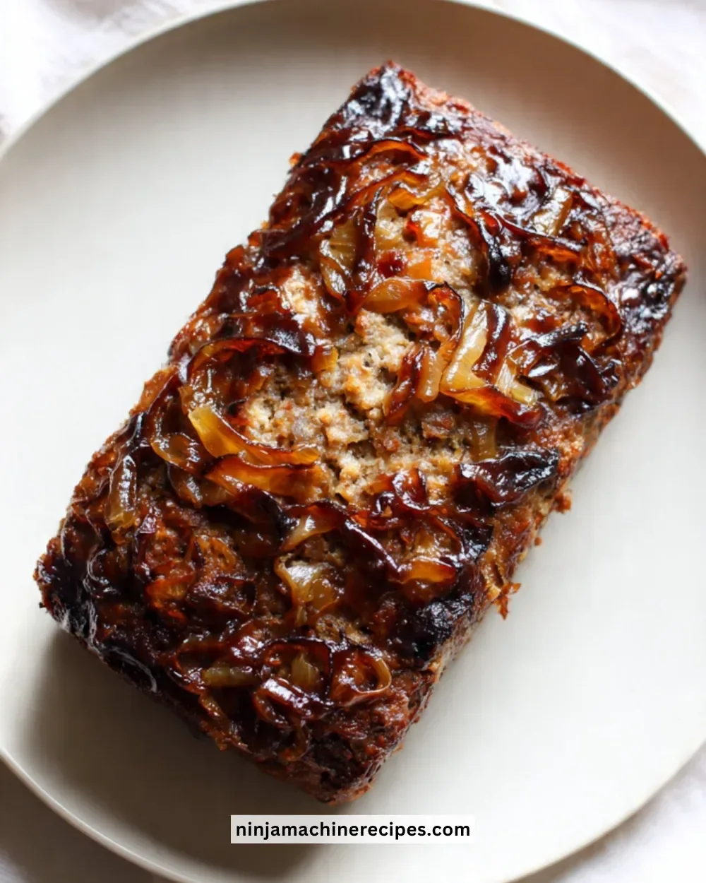 Delicious French Onion Meatloaf topped with caramelized onions and cheese.