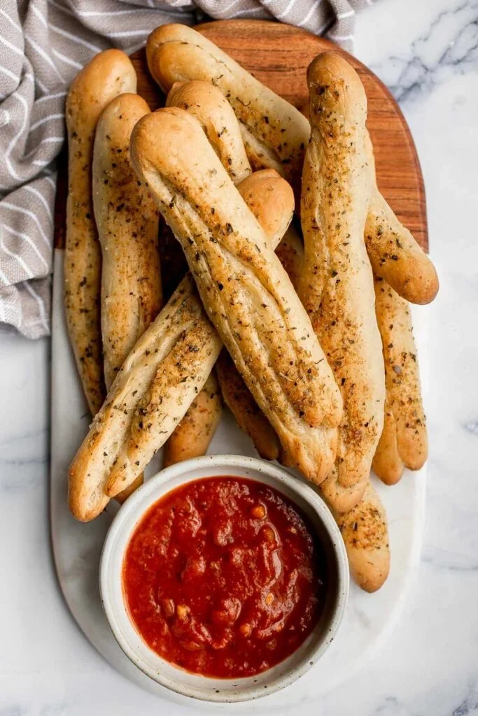 Freshly baked garlic breadsticks served warm with herbs and butter