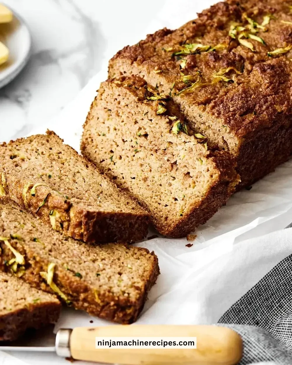 Freshly baked gluten-free zucchini bread sliced on a wooden board