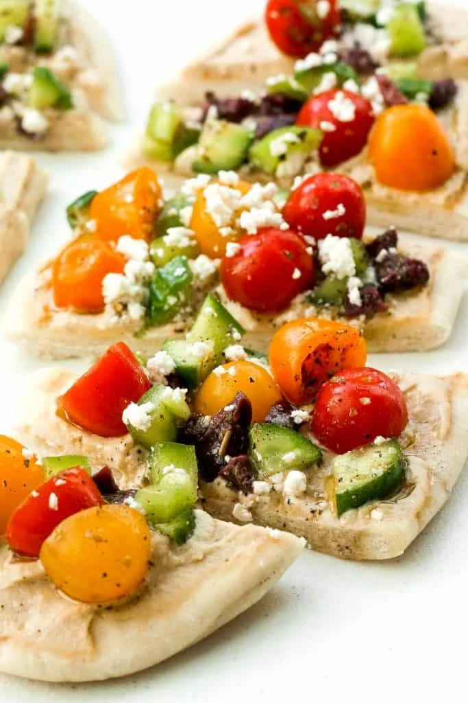 Greek Salad Hummus Flatbread topped with fresh veggies and feta cheese