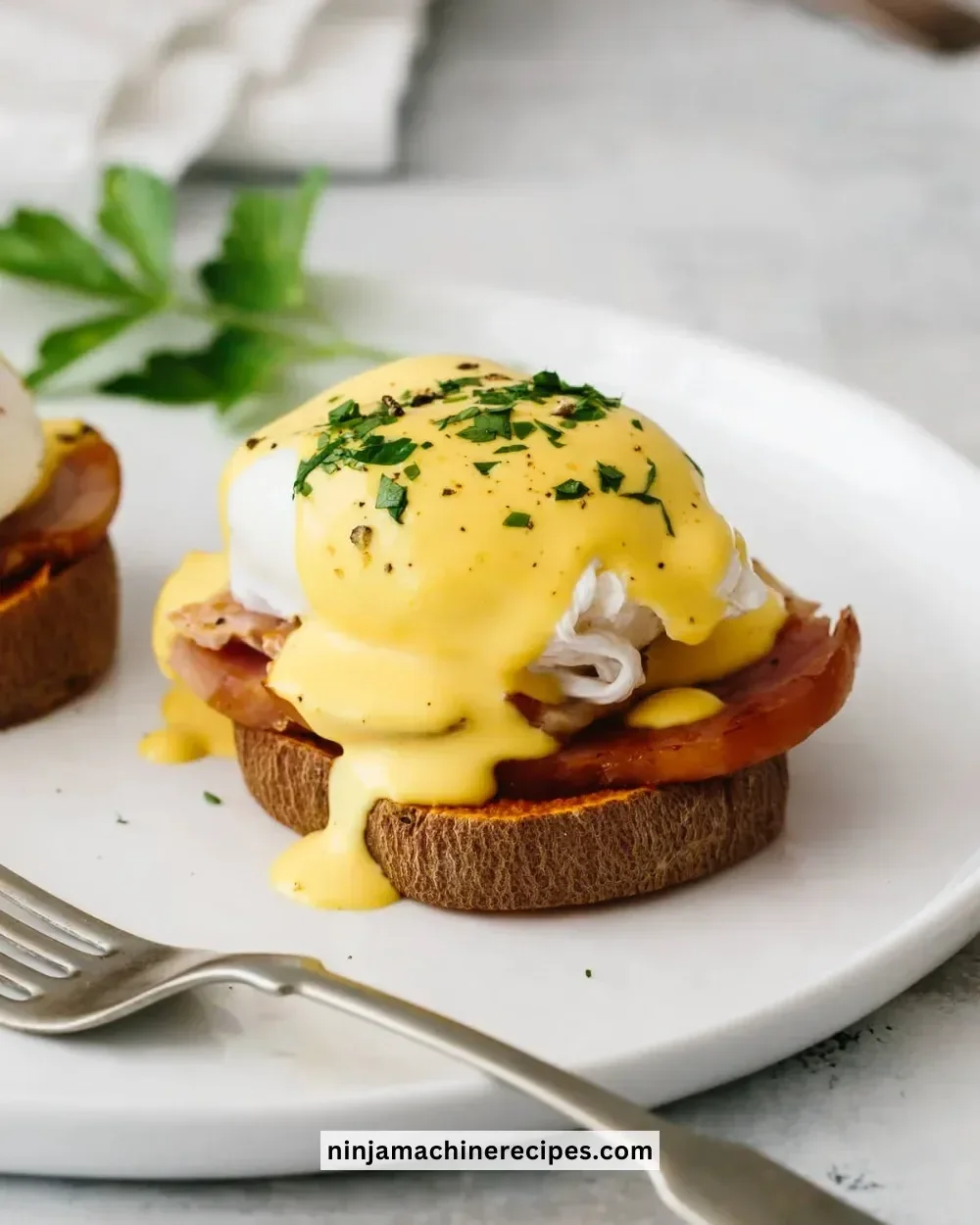 Healthy Eggs Benedict topped with avocado and fresh herbs