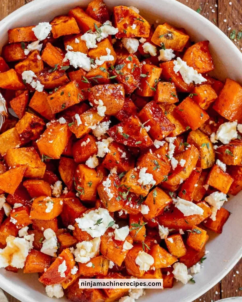Honey roasted sweet potatoes on a plate, garnished with herbs