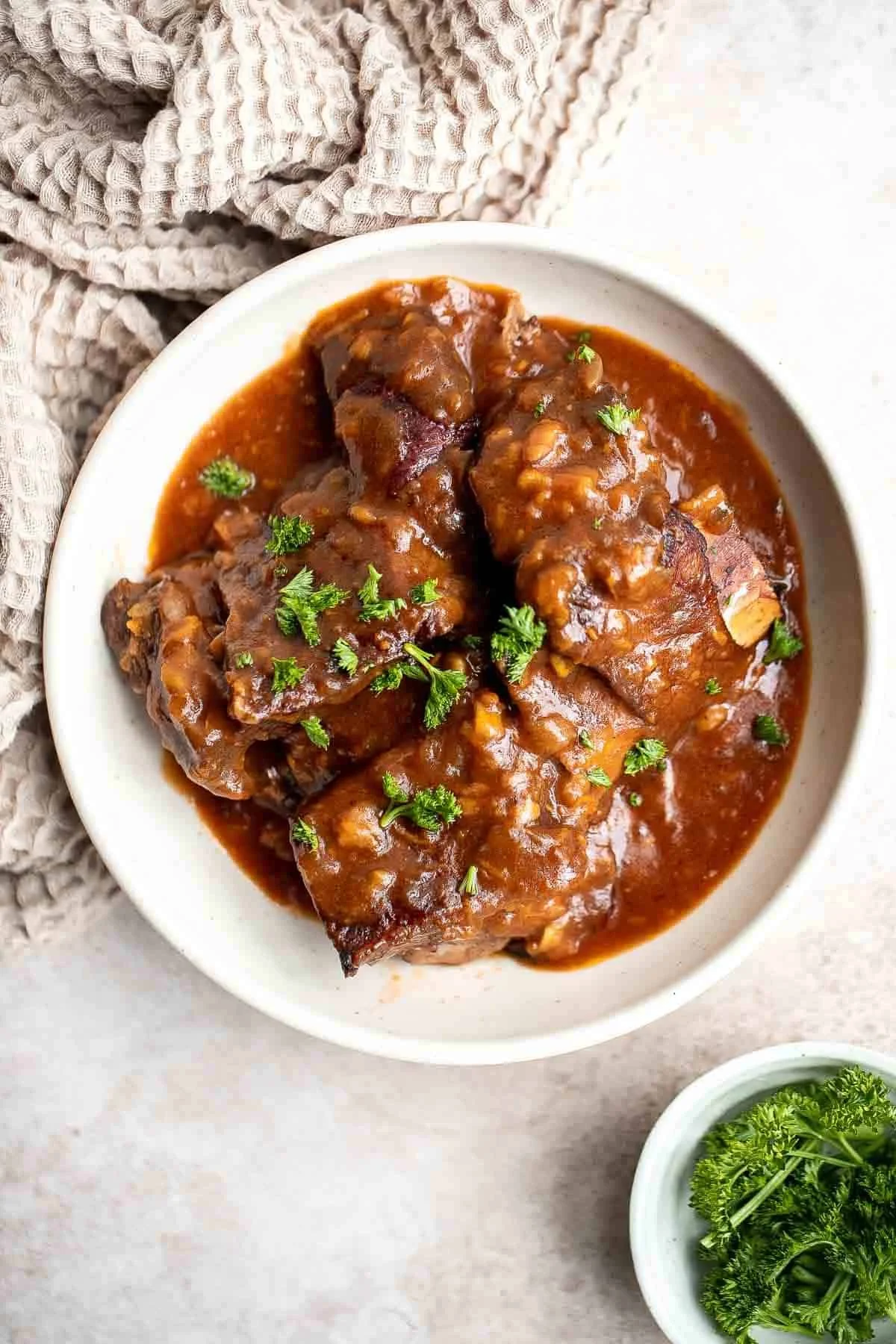 Deliciously tender Instant Pot short ribs served on a plate with garnishes