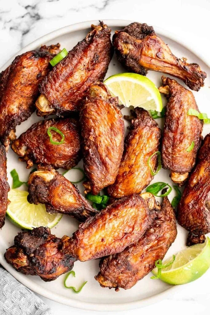 Deliciously grilled jerk chicken wings with vibrant seasoning and garnishes