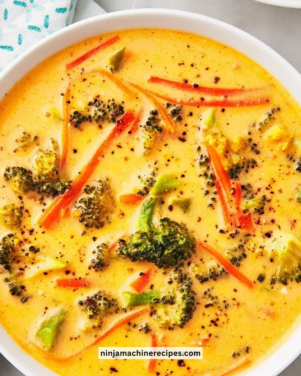 Bowl of Keto Broccoli Cheddar Soup topped with freshly grated cheddar cheese