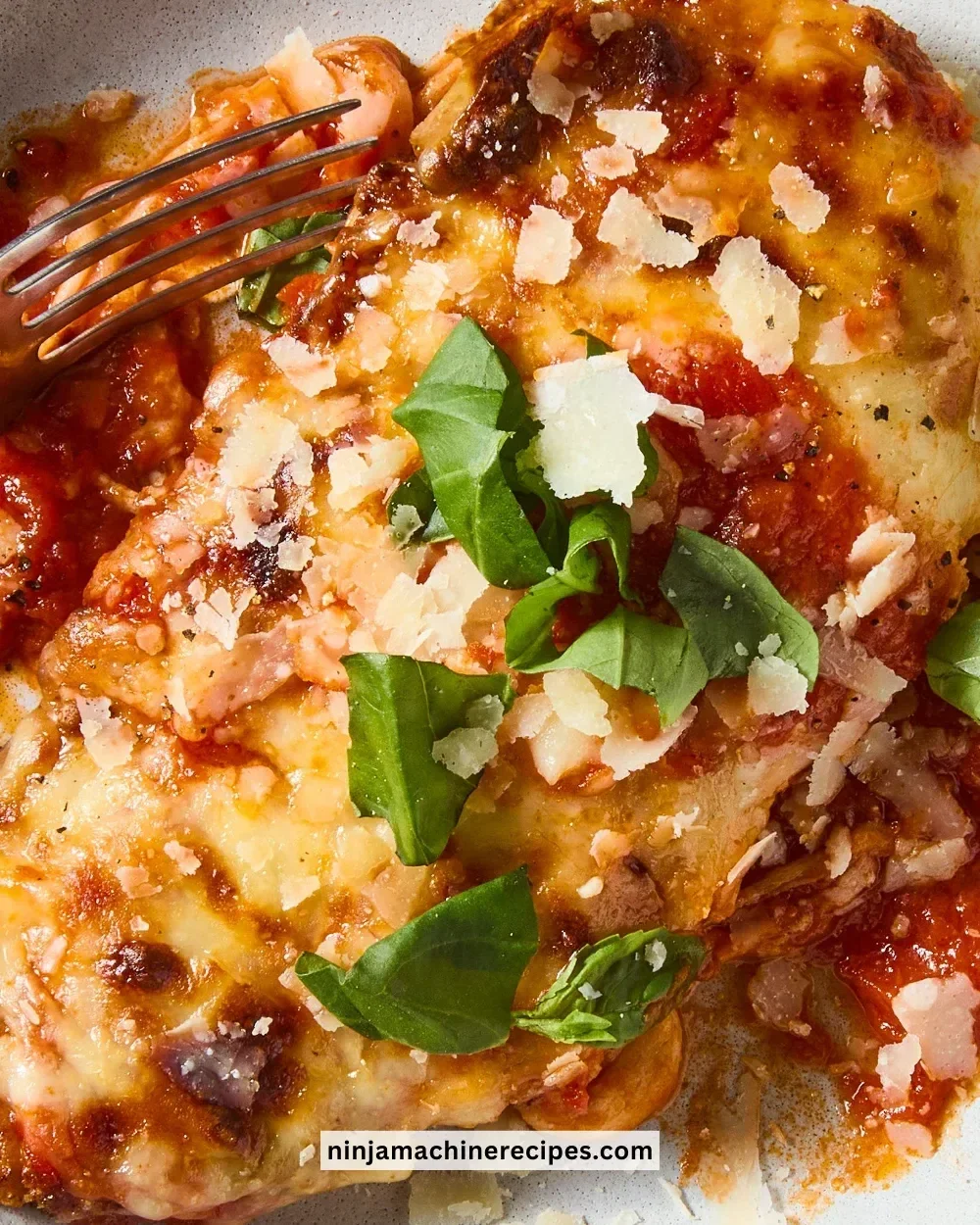 Keto Chicken Parmesan plated with fresh herbs and melted cheese