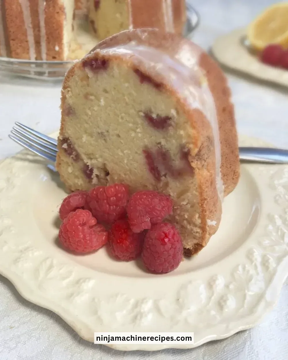Sliced Lemon Raspberry Pound Cake with fresh raspberries and lemon zest