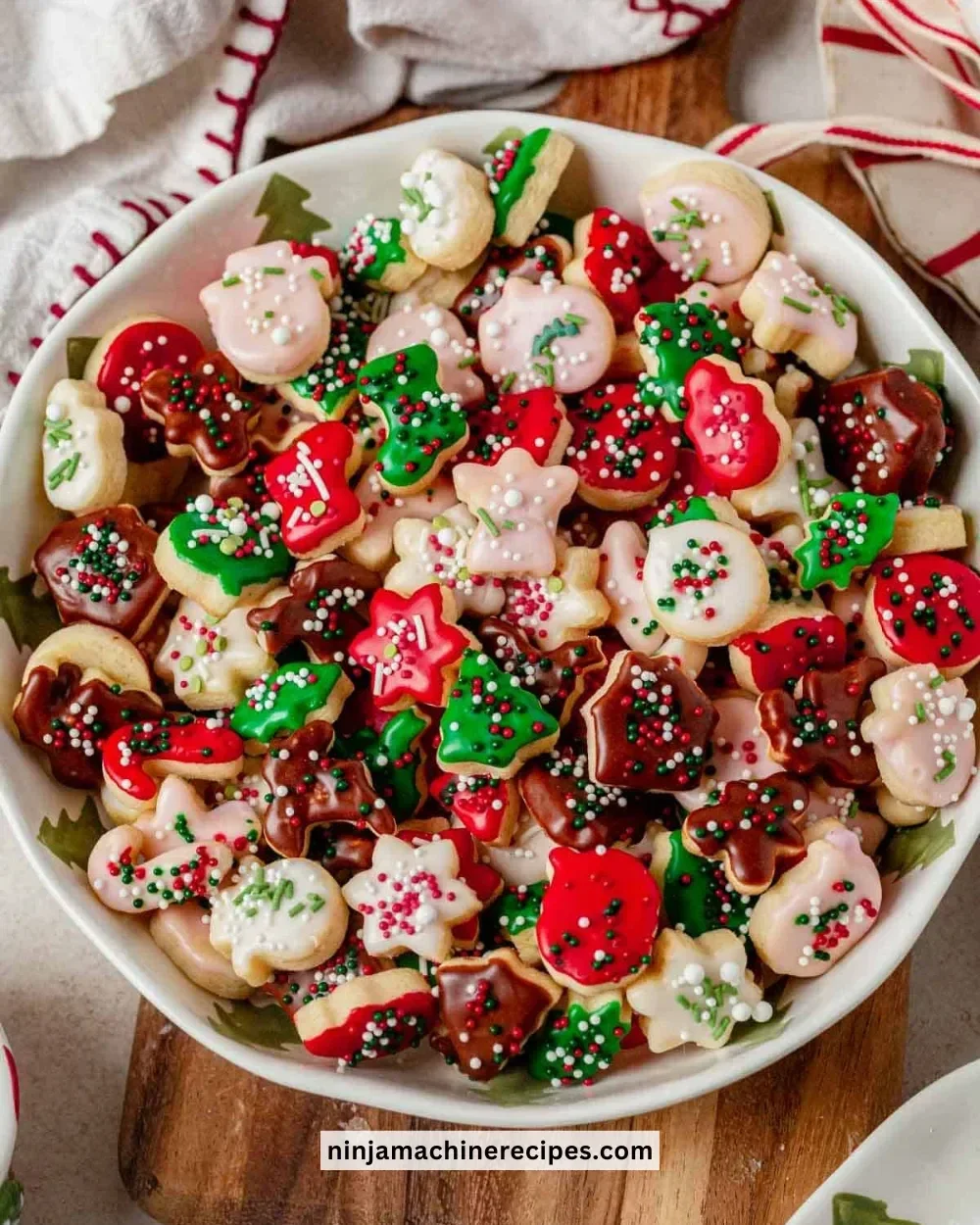 A plate of mini Christmas cookies decorated with festive icing and sprinkles
