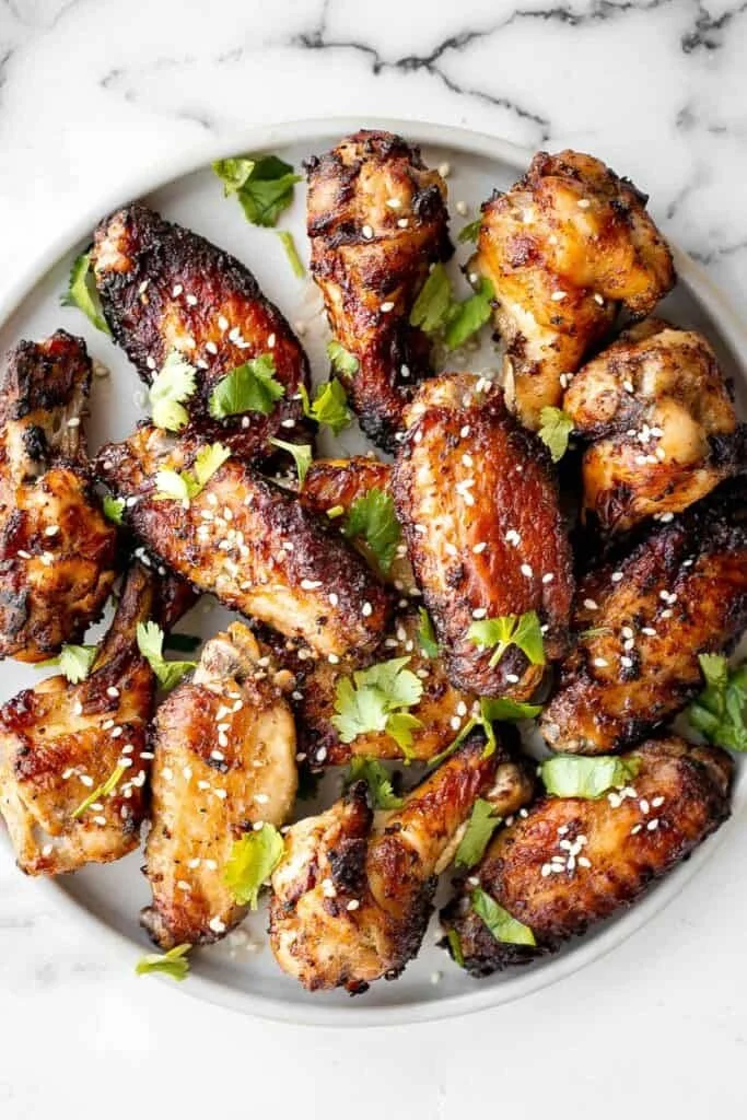 Plate of miso garlic chicken wings garnished with green onions