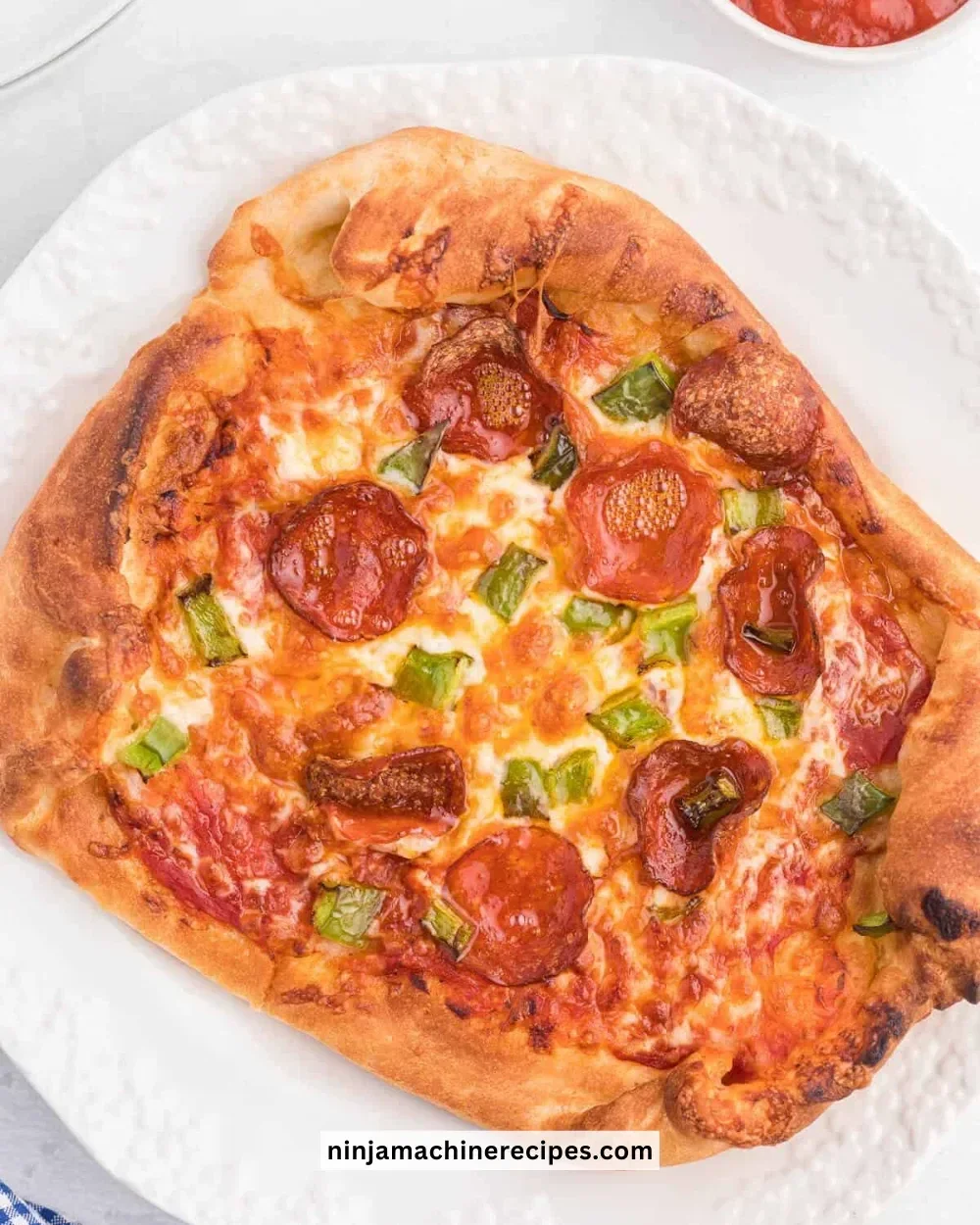 Homemade Ninja Air Fryer Pizza topped with fresh ingredients and cheese.