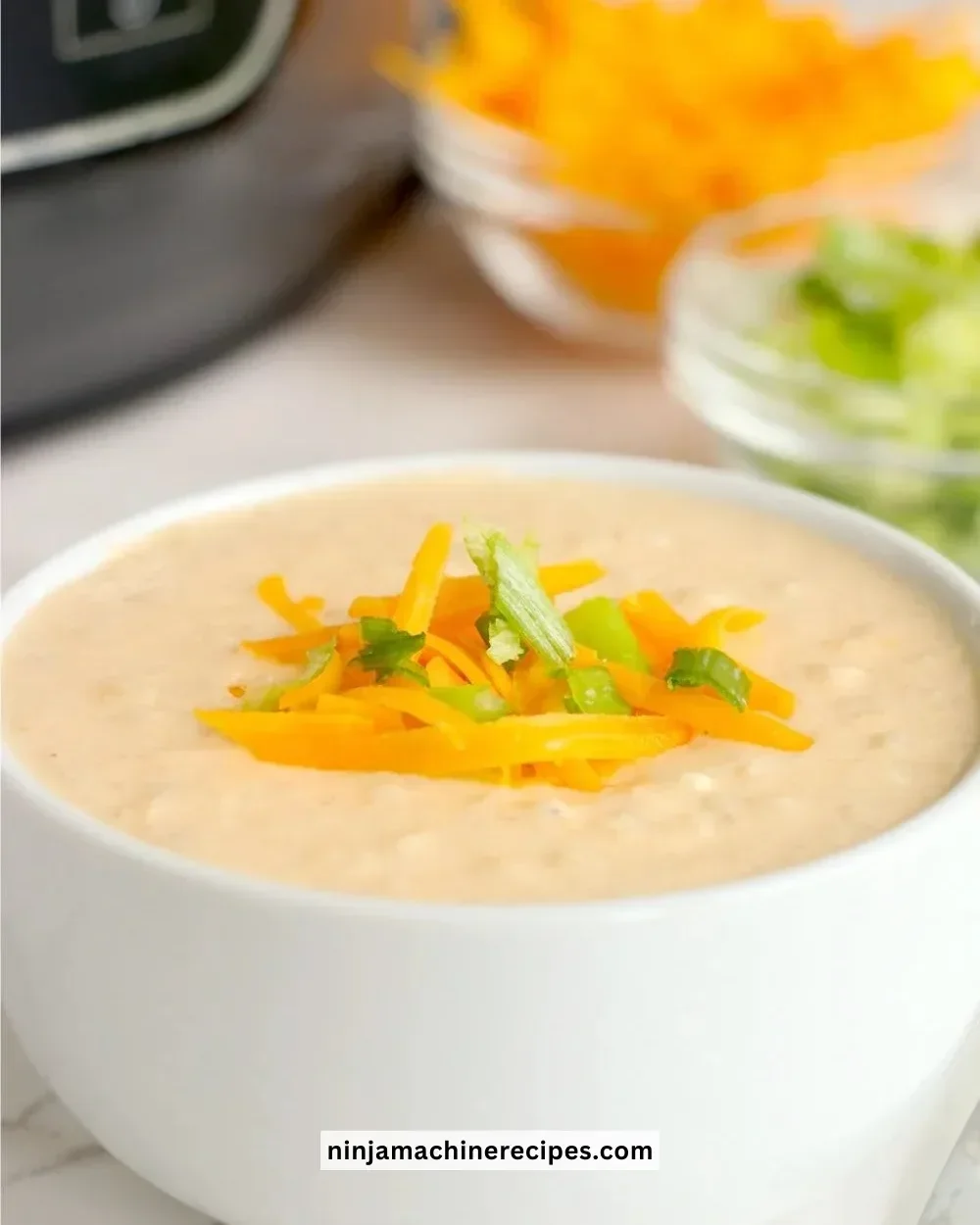 Bowl of creamy Ninja Foodi cheesy cauliflower soup garnished with herbs