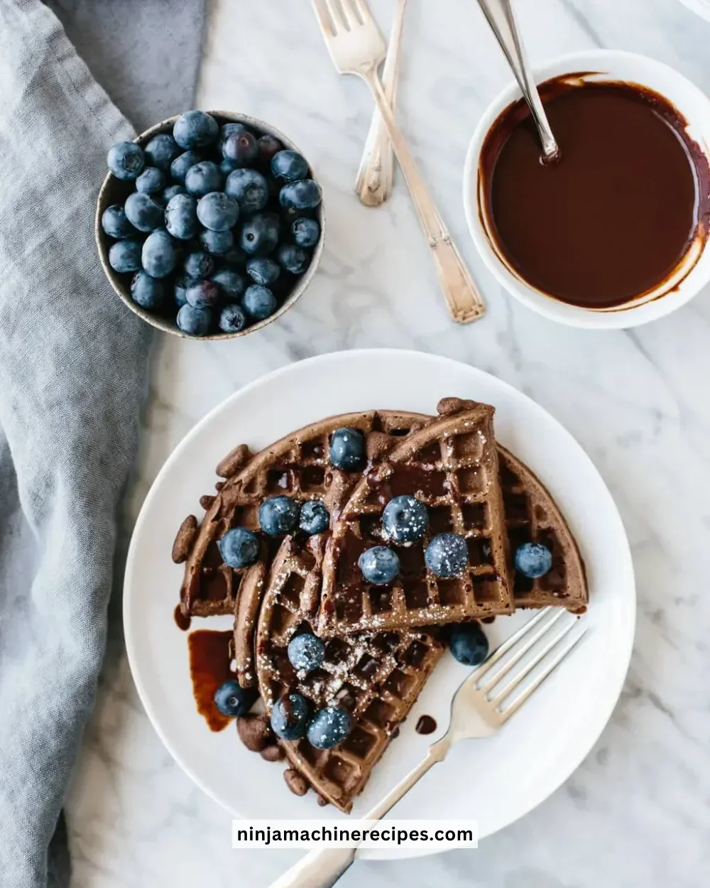 Delicious Paleo chocolate waffles topped with fresh berries and maple syrup