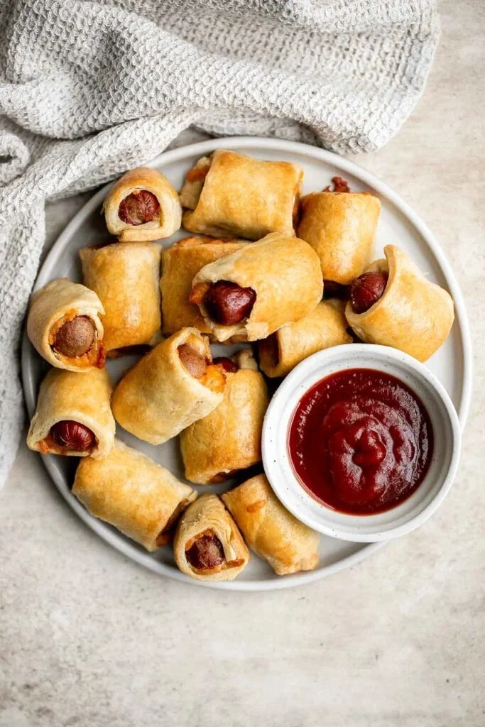 Delicious pigs in a blanket appetizer served on a wooden platter