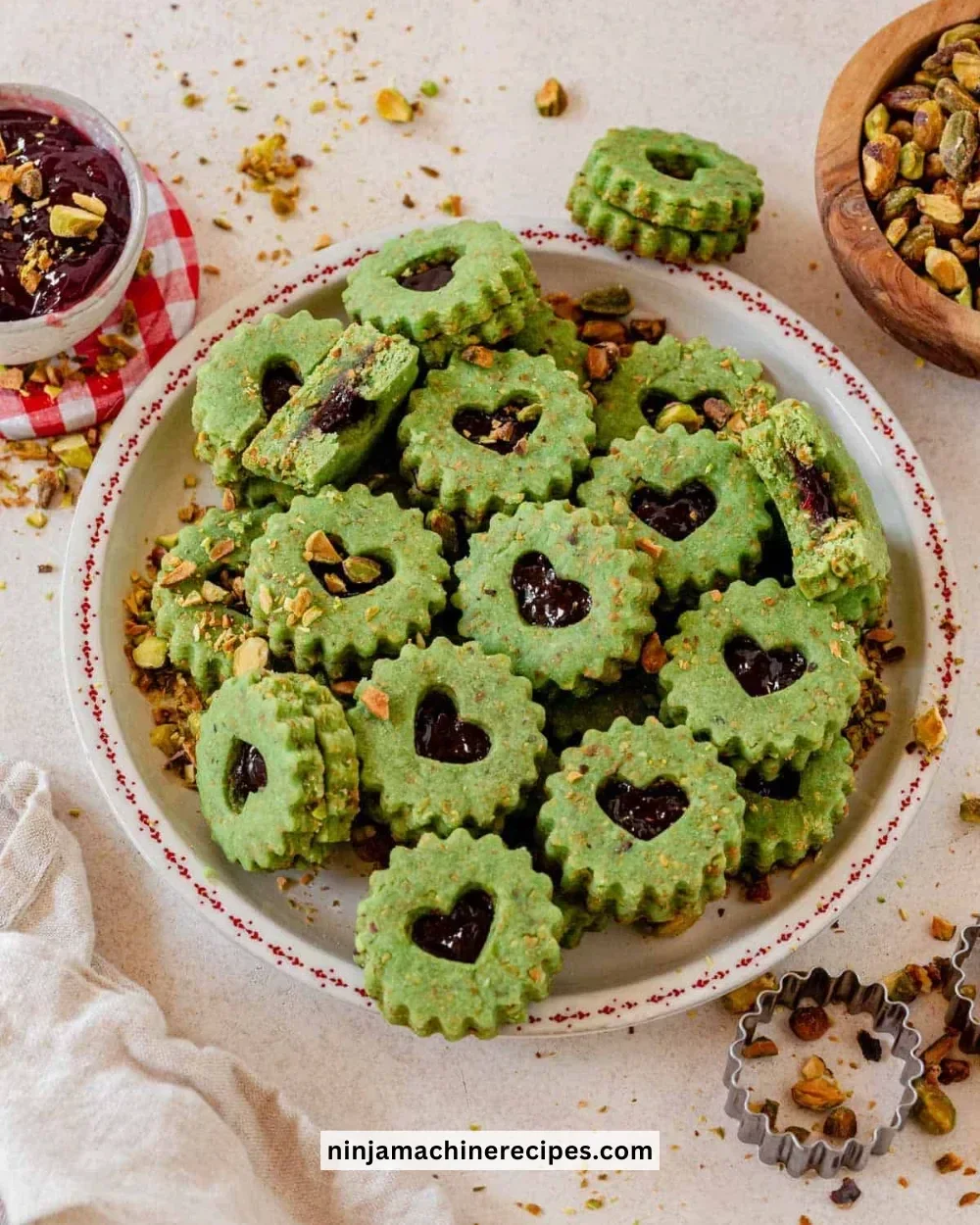 Plate of Pistachio Linzer Cookies with jam filling and powdered sugar