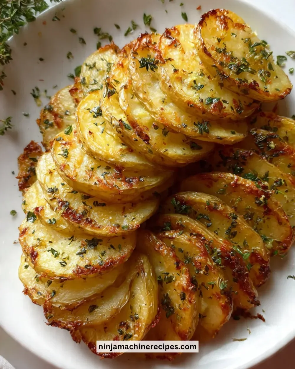Sliced baked potatoes served on a plate, garnished with herbs and spices