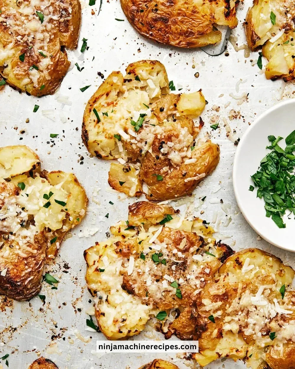Golden-brown smashed potatoes topped with herbs and spices.