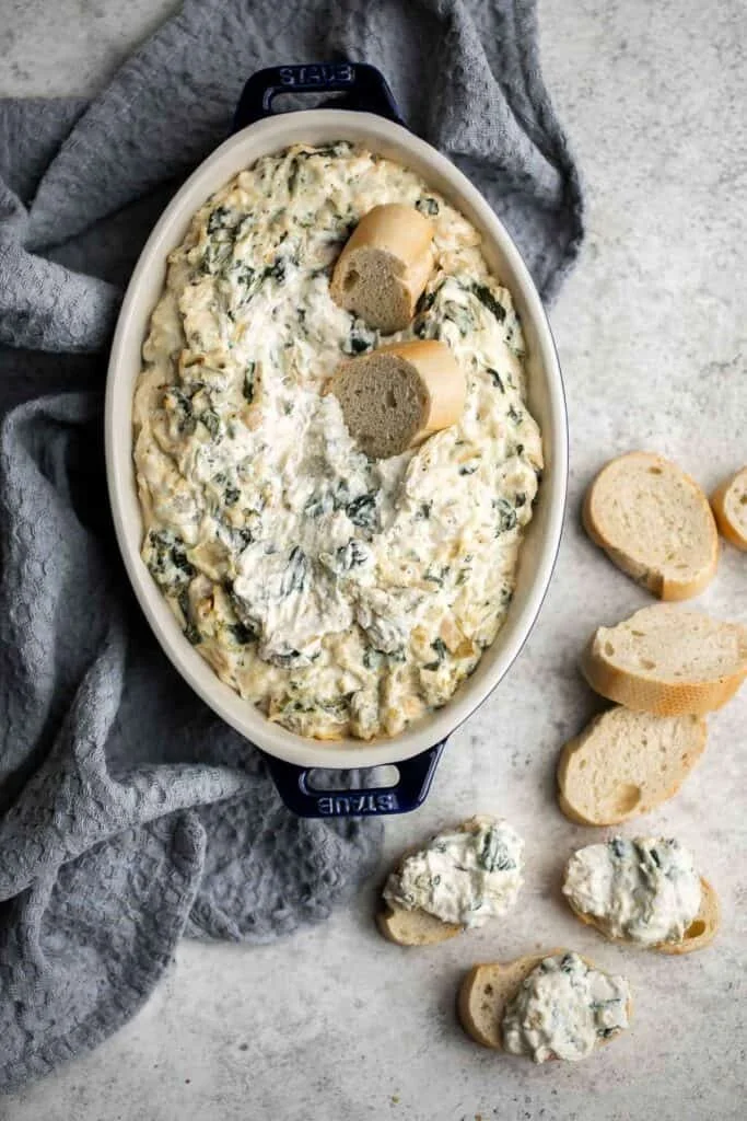Delicious Spinach Artichoke Dip served in a bowl with tortilla chips.