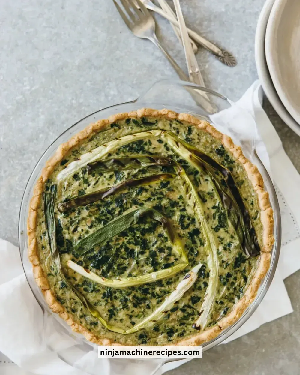 Delicious Spinach Artichoke Quiche served on a plate with fresh herbs