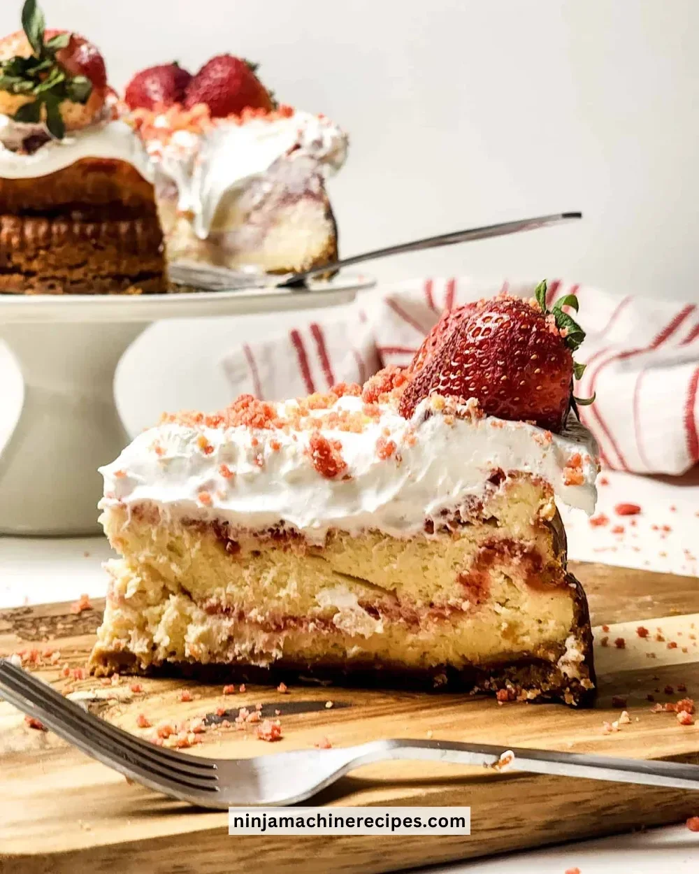 Delicious slice of Strawberry Crunch Cheesecake with fresh strawberries and crunch topping