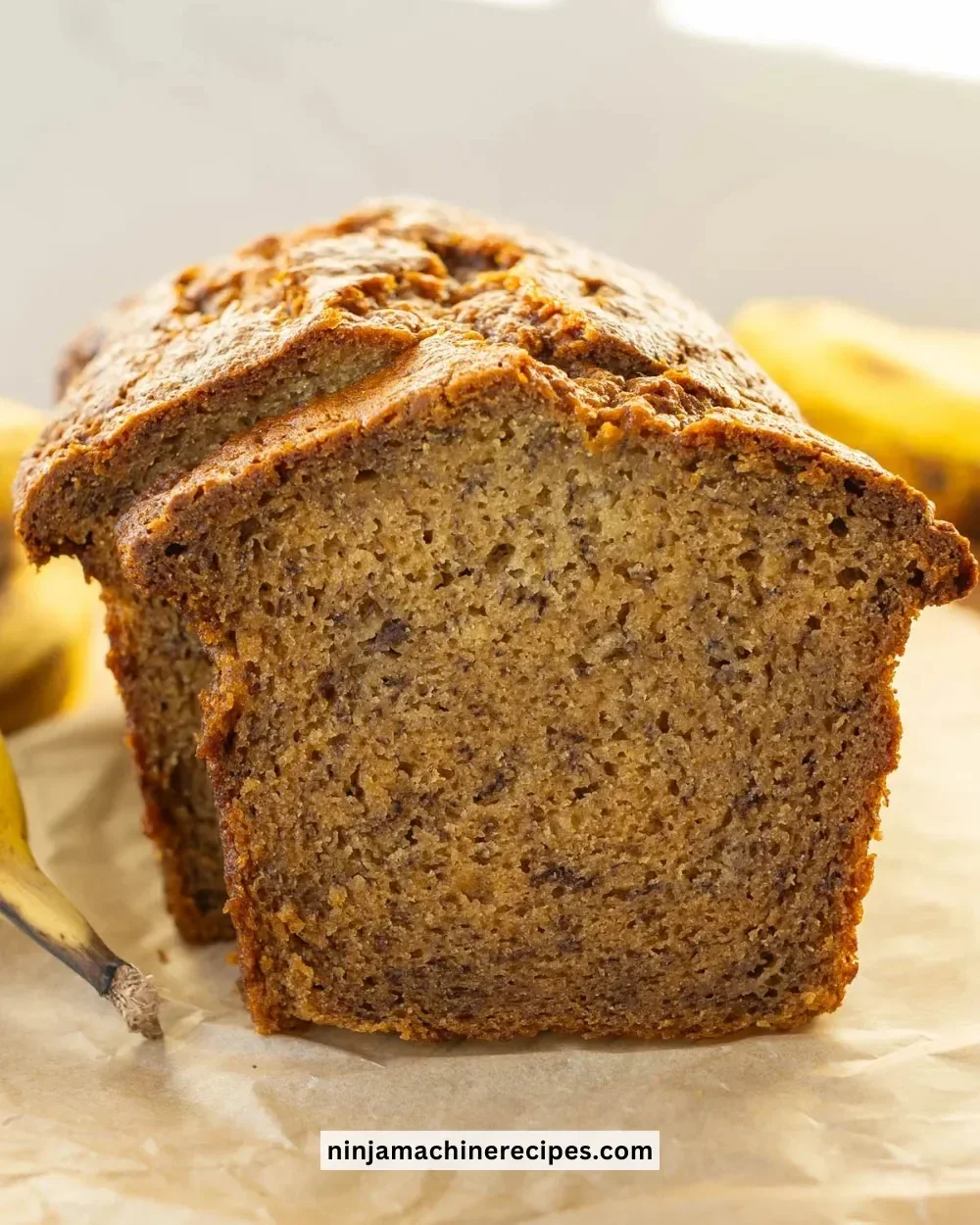 Sliced super moist banana bread on a wooden cutting board