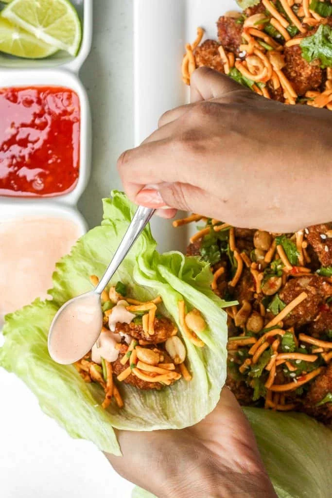 Szechuan chicken lettuce wraps with spicy mayo drizzled on top