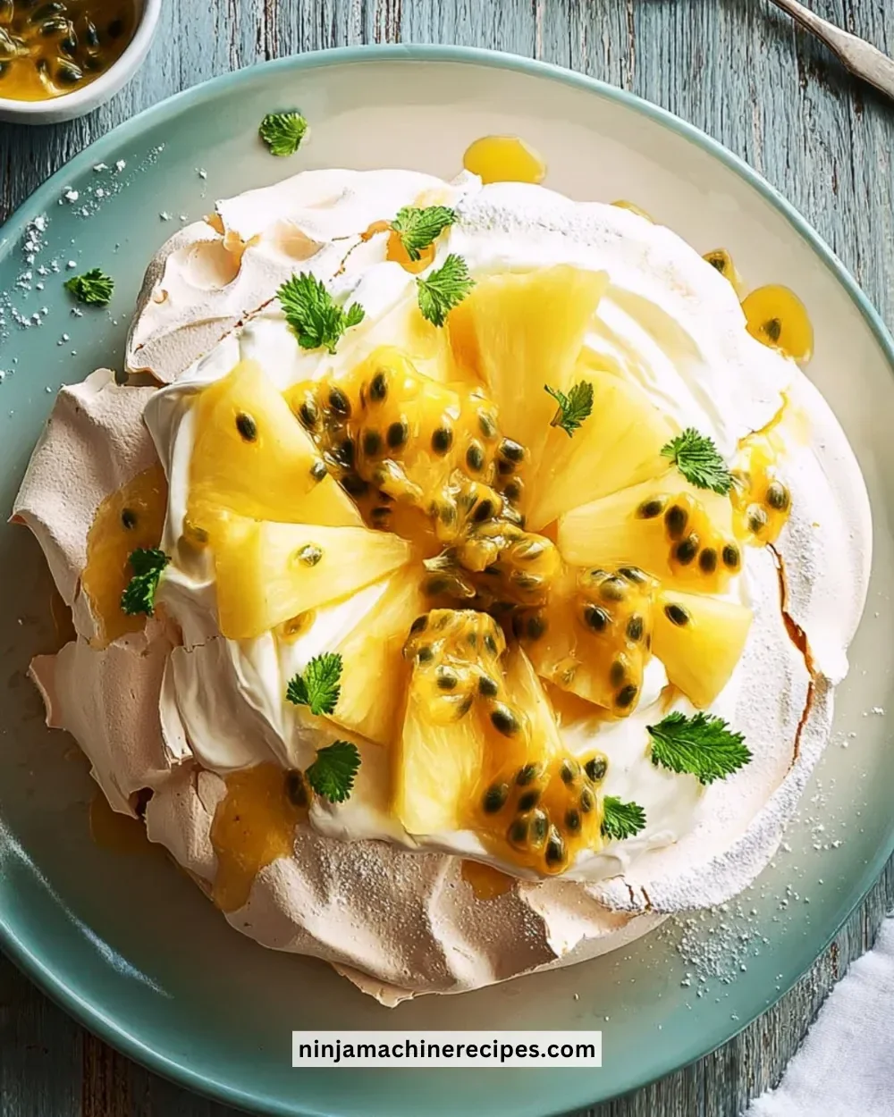 Delicious Vanilla Pavlova topped with pineapple and passion fruit on a plate.