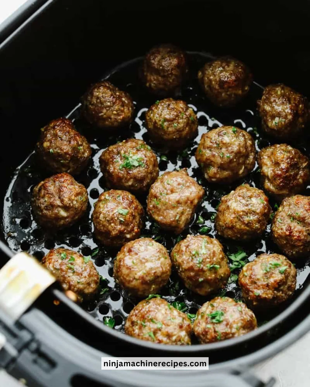 Delicious air fryer meatballs served with marinara sauce and garnished with herbs.