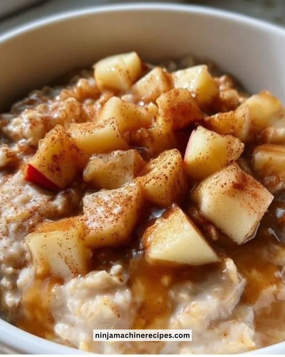 Bowl of apple cinnamon oatmeal topped with fresh apples and cinnamon