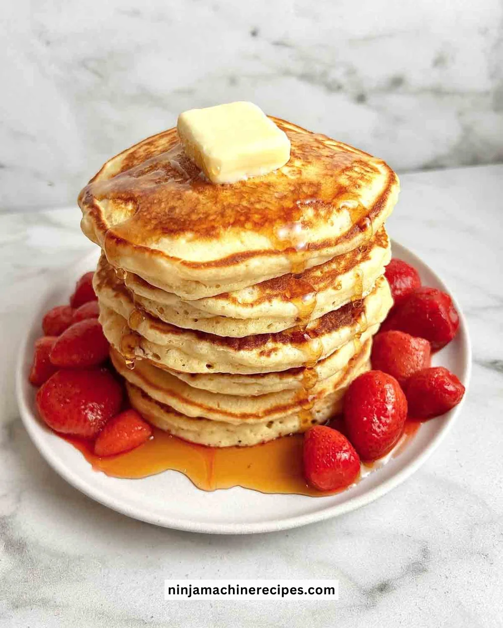 Stack of fluffy pancakes topped with maple syrup and fresh berries
