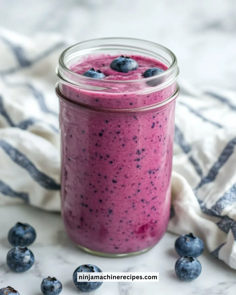 Delicious blueberry smoothie topped with fresh blueberries and mint leaves