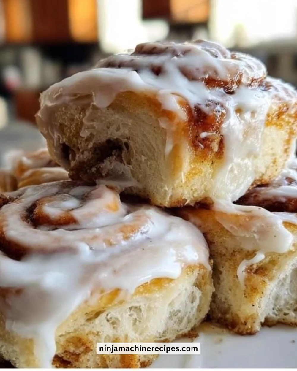 Freshly baked cinnamon buns with gooey frosting on top.