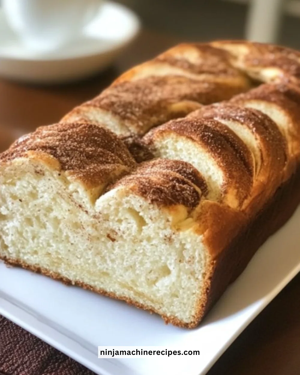 Freshly baked cinnamon donut bread with a golden crust and cinnamon sugar topping.