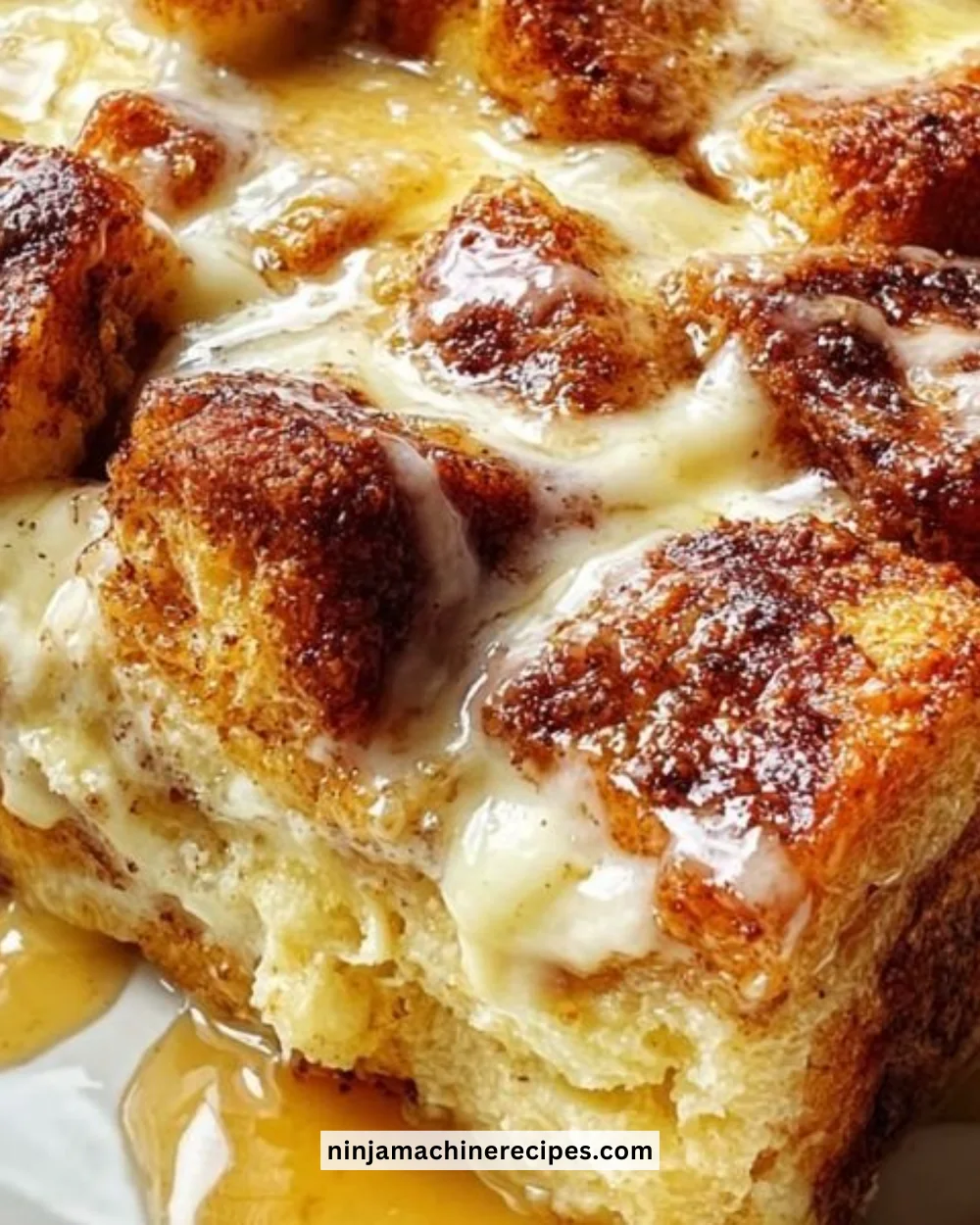 Delicious cinnamon roll bread pudding topped with icing and served warm.