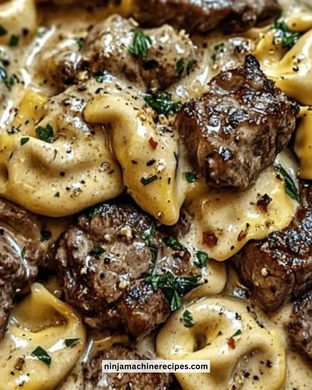 Creamy Cracked Garlic Steak Tortellini served in a white sauce dish