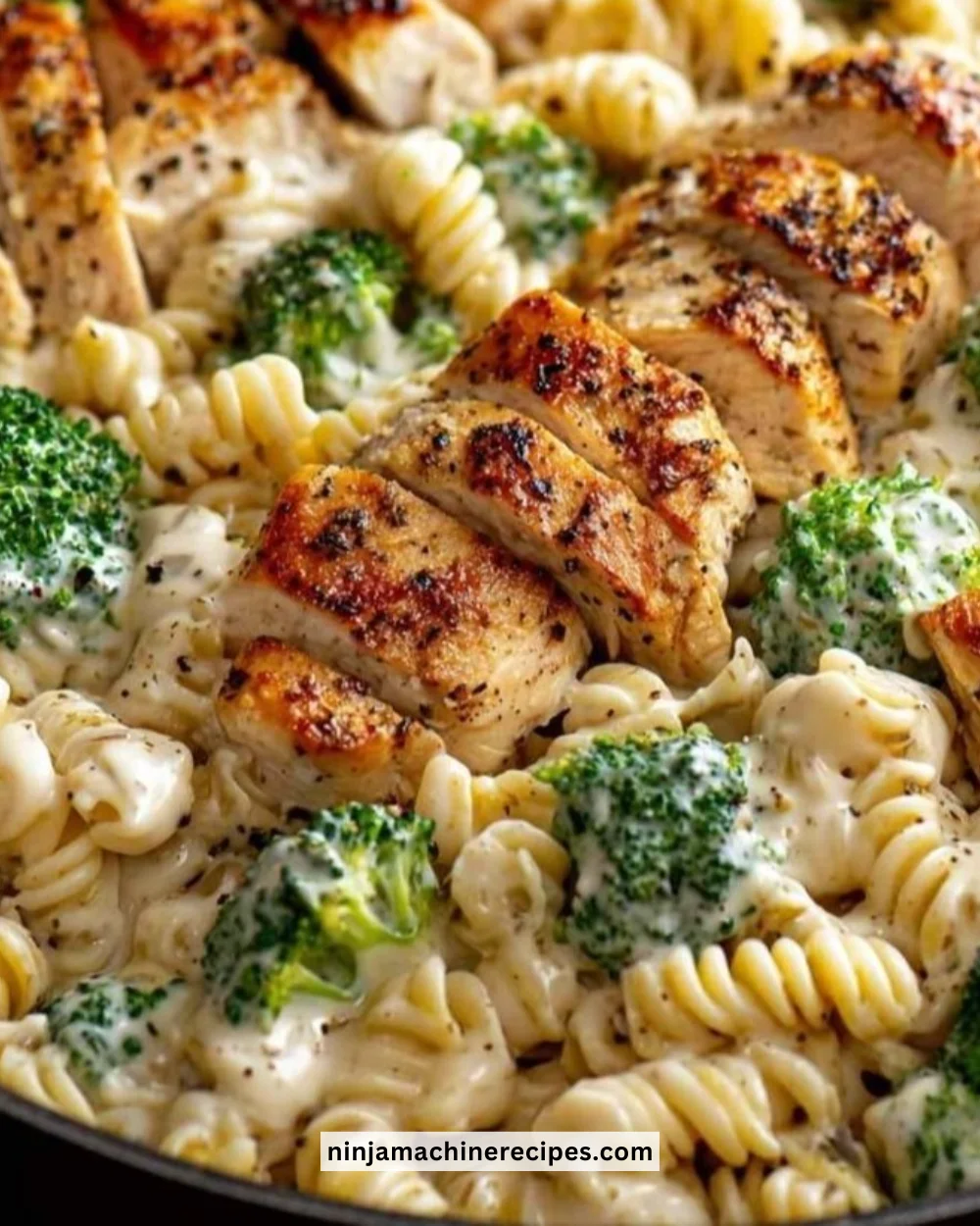 Creamy rotisserie chicken broccoli pasta in a bowl garnished with parsley