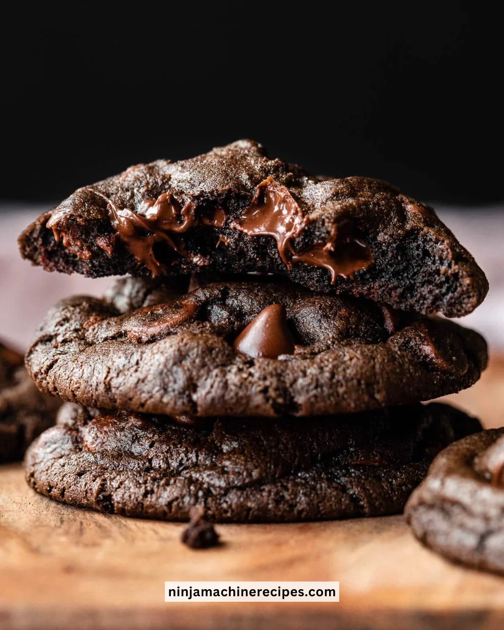 Freshly baked double chocolate chip cookies stacked on a plate