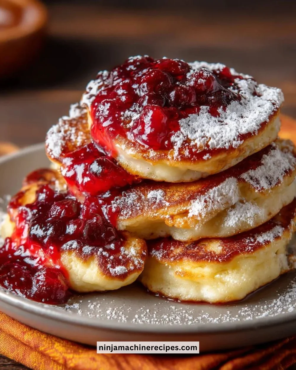 Stack of fluffy homemade pancakes topped with syrup and berries