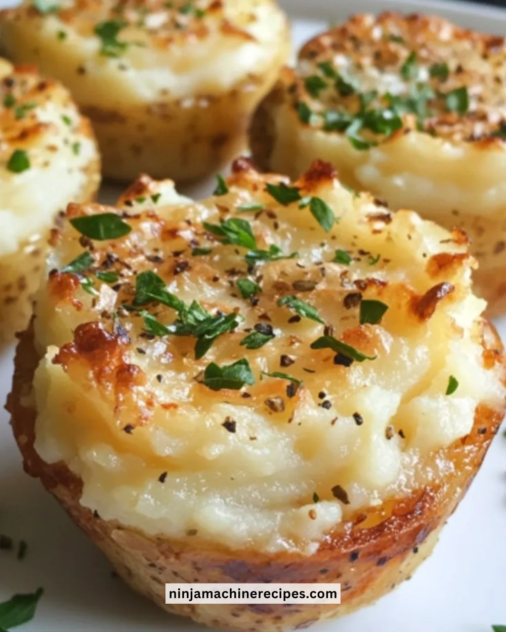 Garlic Parmesan Mashed Potato Cups served on a plate, garnished with herbs