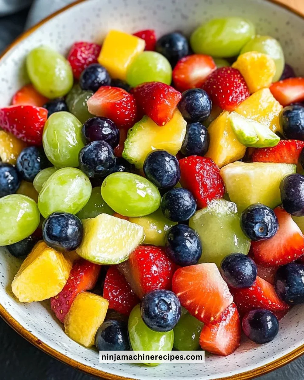 Colorful honey lime fruit salad served in a bowl, showcasing fresh fruits.